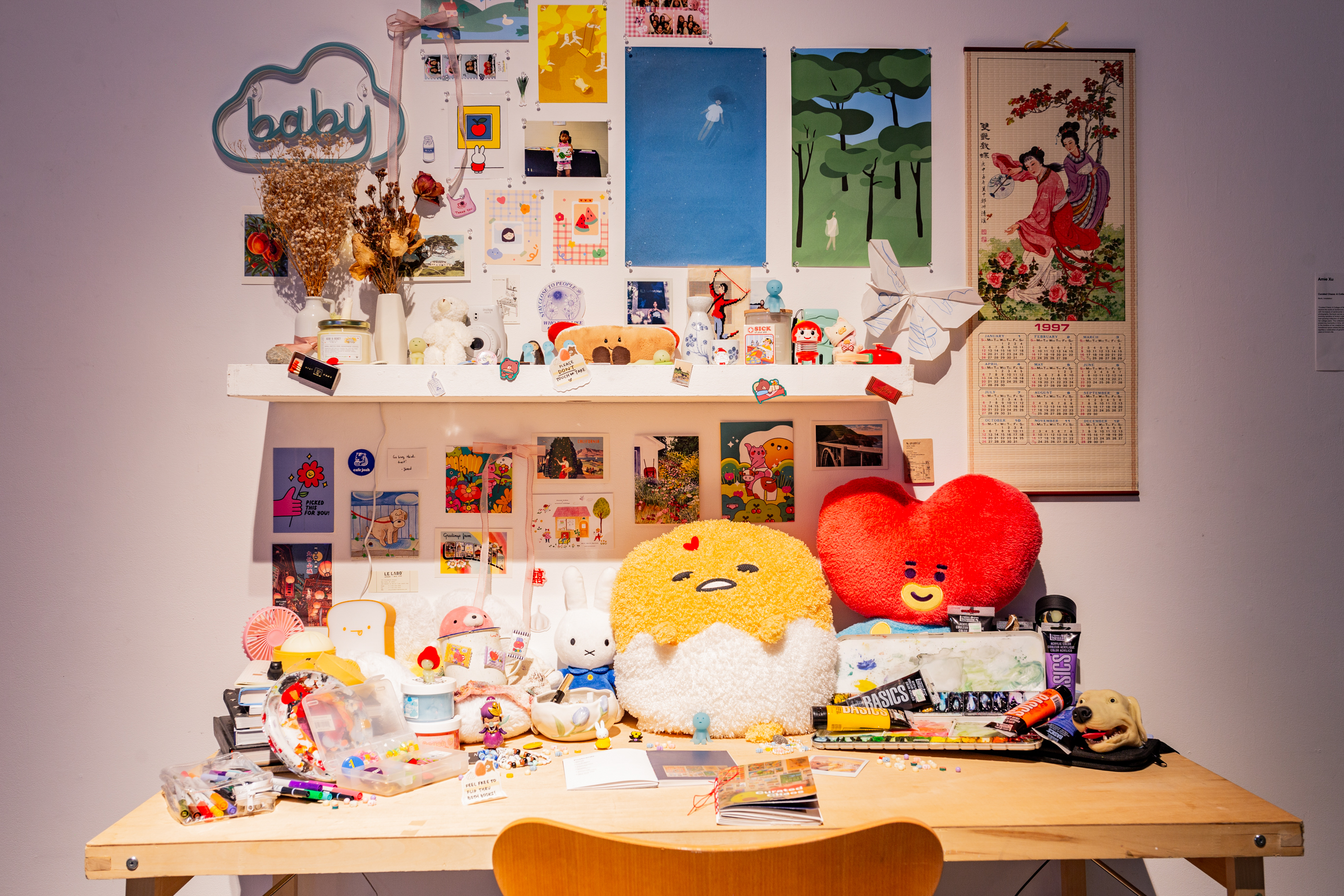 A wooden desk overly decorared with various plushies, collectibles, and printed photos.